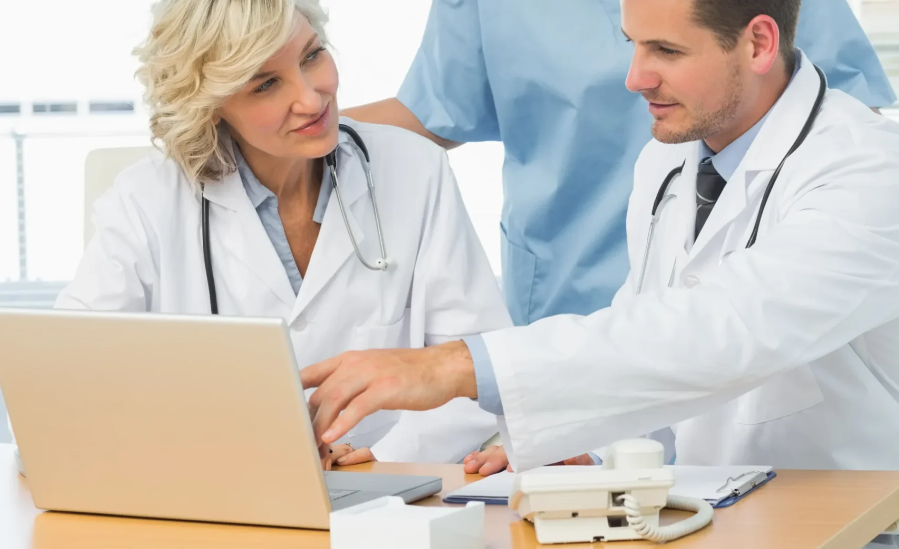 doctors-using-laptop-together-medical-office